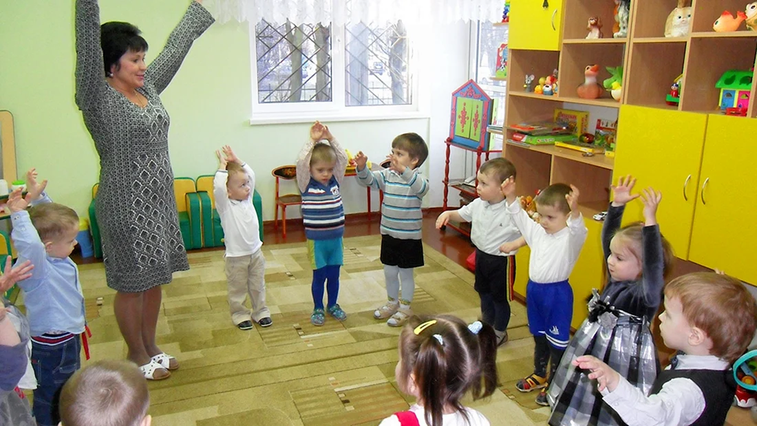 Воспитатель и дети в детском саду